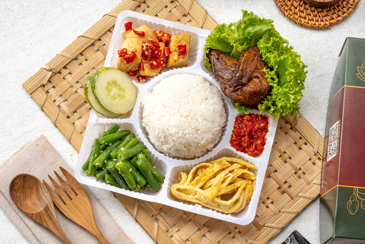 Nasi box Vigee Catering dengan lauk lengkap di atas alas anyaman