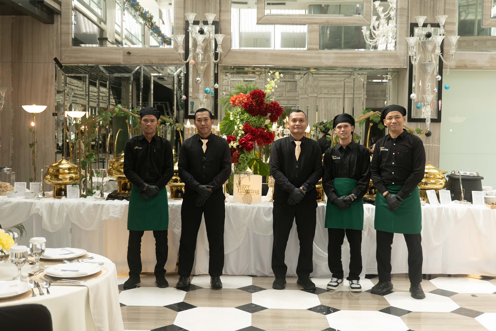Tim servis Vigee Catering berjaga di depan meja prasmanan